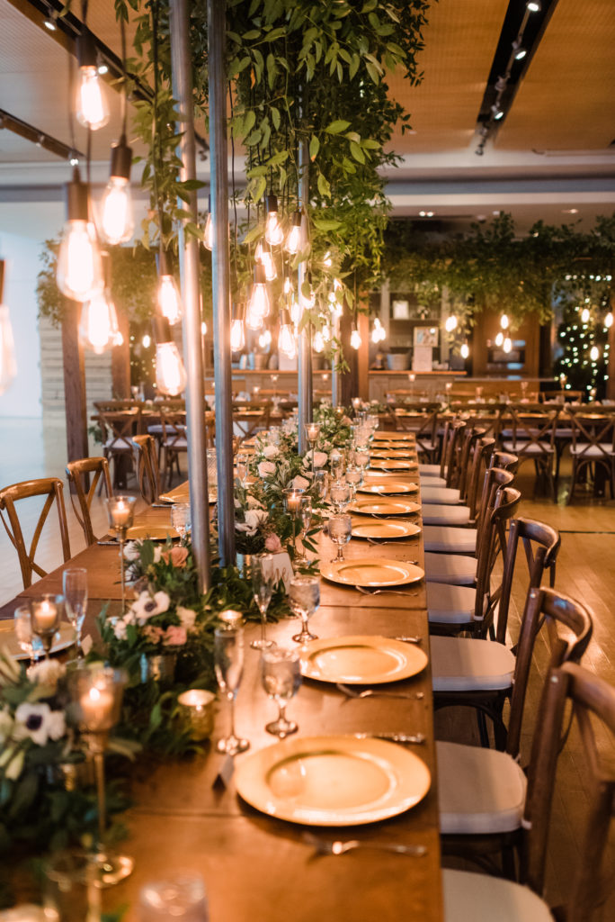 Guest table with gold chargers and hanging lights