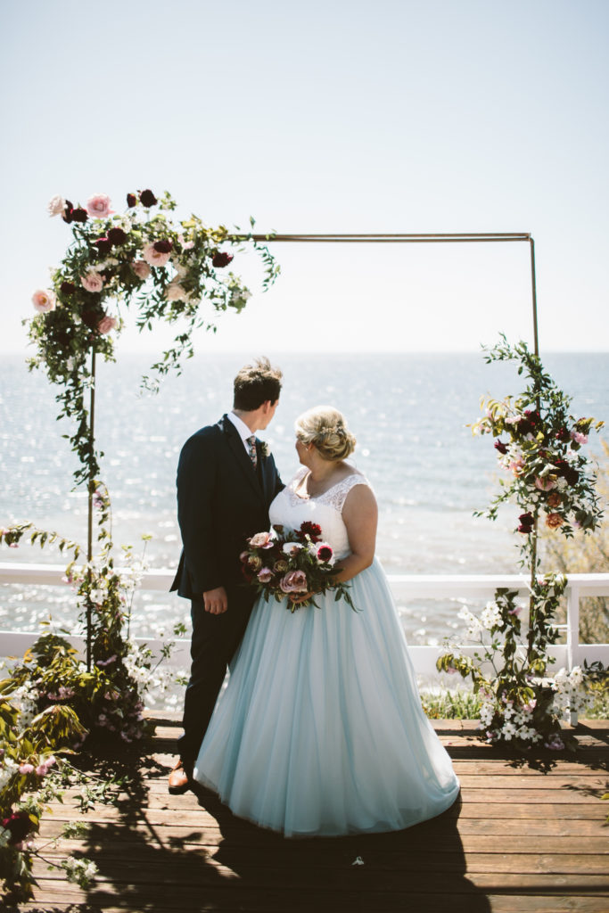 Ceremony over Lake Michigan with a floral covered copper arbor